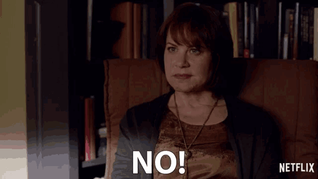 a woman is sitting in a chair with the word no on her face