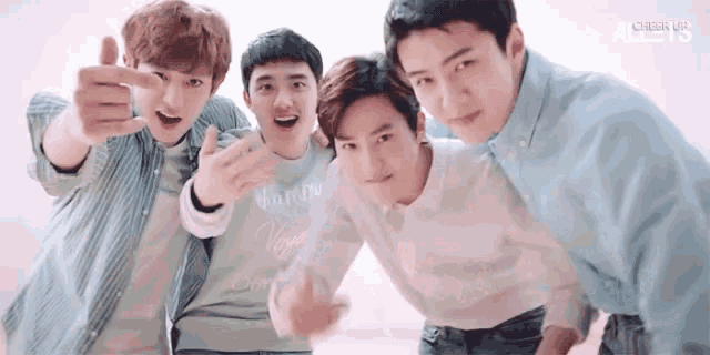 a group of young men are posing for a picture together while pointing at the camera .