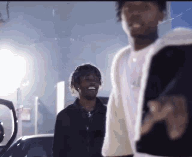 two young men are standing next to each other and one is smiling