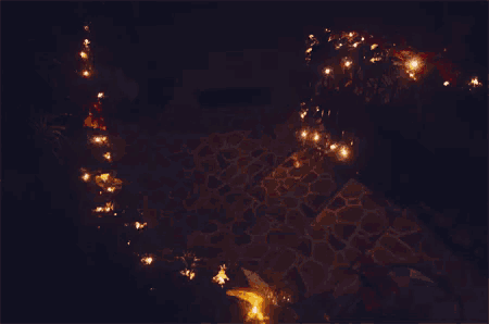 a stone walkway is lit up at night