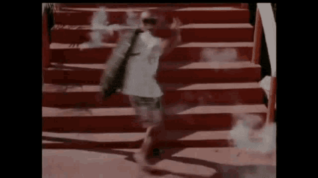 a man is walking down a set of red stairs with smoke coming out of his mouth .