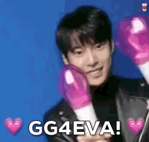 a young man is wearing pink boxing gloves and holding a heart shaped stick .