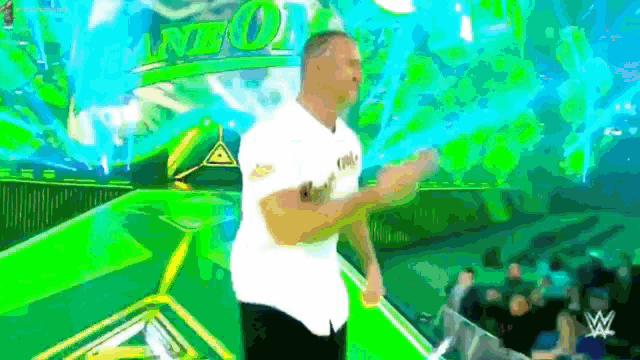 a man in a white shirt is dancing in front of a screen that says nwo