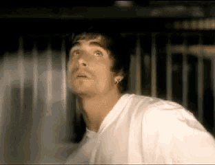 a man in a white shirt is looking up at the sky