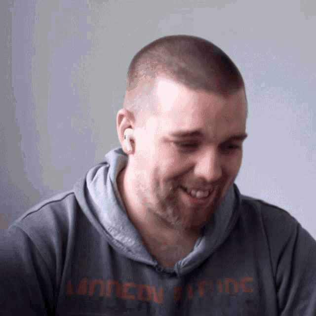a man wearing a minnesota pride hoodie smiles