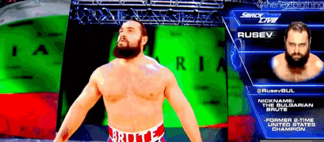 a man with a beard is standing in front of a green screen that says rusev