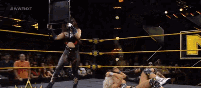 a group of wrestlers are fighting in a ring with a crowd watching .