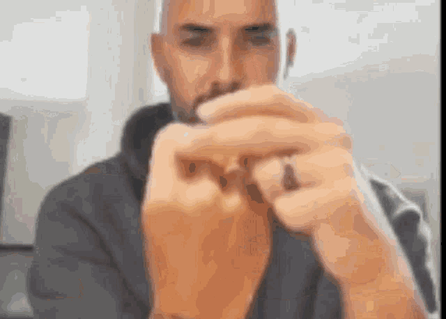 a man with a beard is holding a piece of paper in his hands .