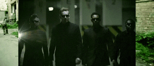 a group of men are walking down a dark alleyway