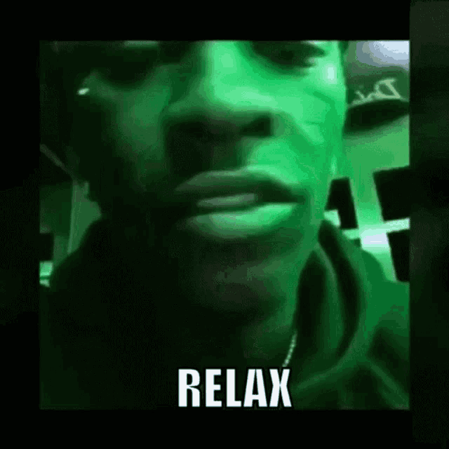 a close up of a man 's face with a green background and the words `` relax '' written on it .