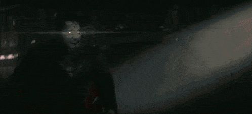 a man in a superhero costume is holding a flashlight in his hand