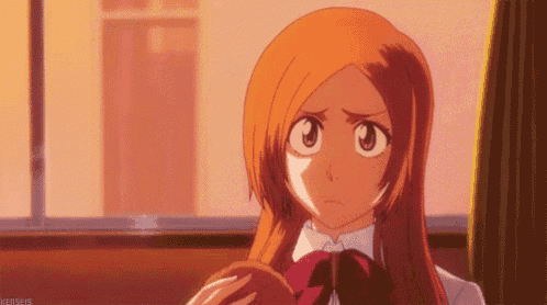 a girl with long orange hair is sitting in front of a window and looking at something .