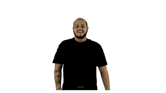 a man with a beard is smiling and clapping with the words buena esa behind him