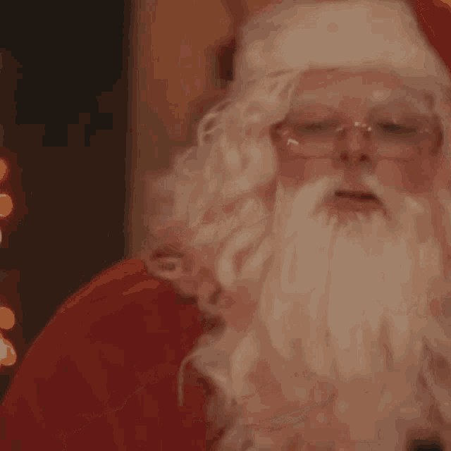 a close up of a man dressed as santa claus with glasses and a beard