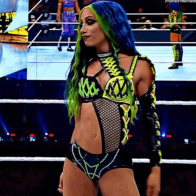 a woman with blue and green hair is standing in a ring