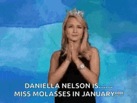 a woman wearing a tiara is covering her mouth with her hands .
