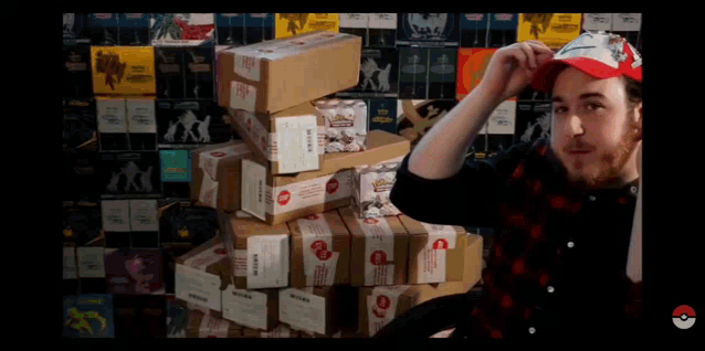 a man in a red hat stands in front of a stack of boxes with one that says ' pokemon '