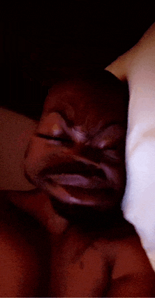 a close up of a person 's face with a white pillow behind them