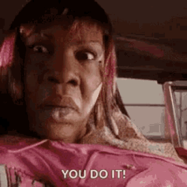 a woman in a pink shirt is sitting in a car and says `` you do it ! ''