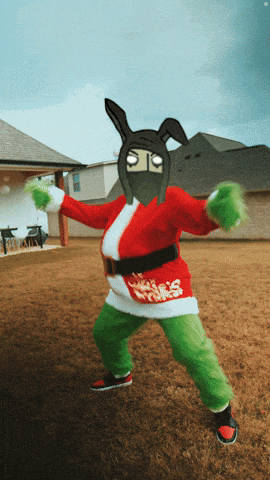 a person in a santa suit and green pants stands in a field