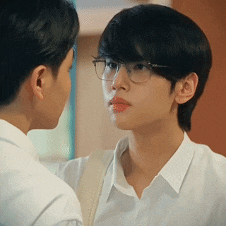 a man wearing glasses is looking at another man .