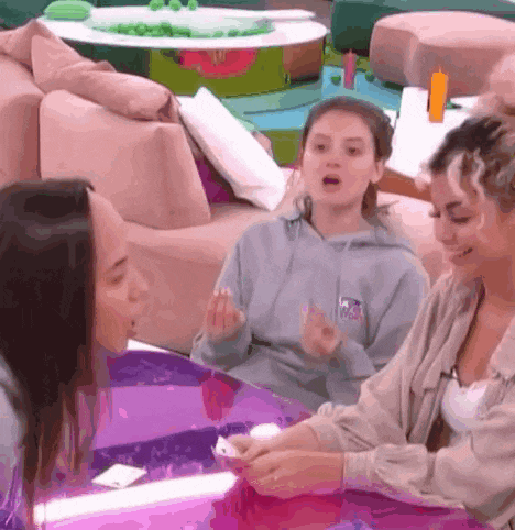 a group of women are sitting around a table playing a game .