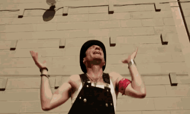 a man wearing overalls and a bandana is juggling a light bulb