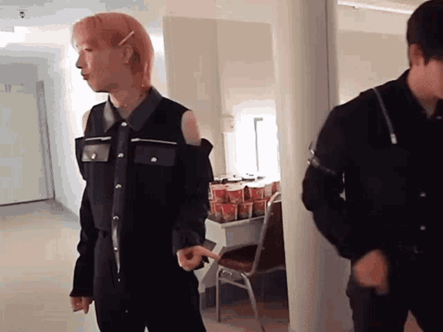 a woman with pink hair is standing next to a man in a black shirt