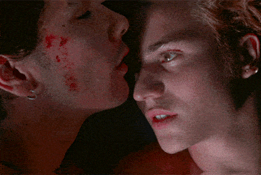 two men kissing with blood on their faces