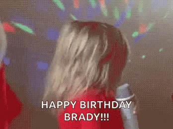 a woman is dancing in front of a microphone and says happy birthday brady .