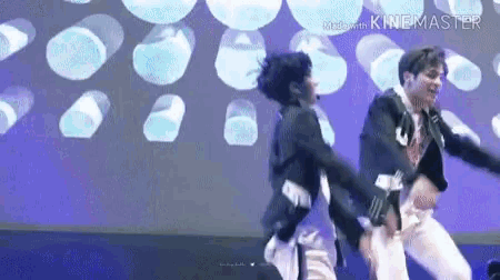 two men are dancing together on a stage in front of a blue background .