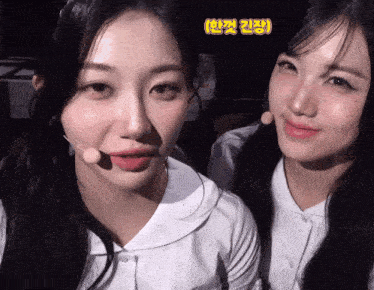 two girls are standing next to each other and one of them is wearing a white shirt