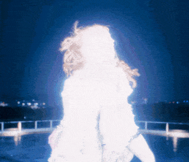 a woman in a white dress is standing in the dark