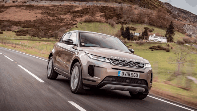 a range rover driving down a road with a license plate that says ovis sco