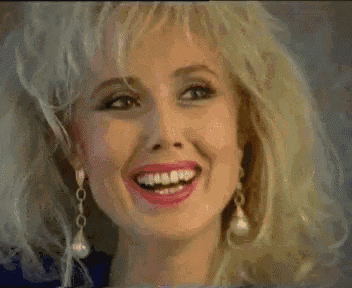 a woman with blonde hair and pink lips is smiling