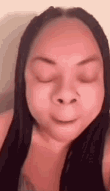 a close up of a woman 's face with her eyes closed and her mouth open .