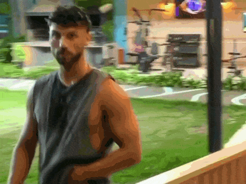 a man without a shirt is standing in a grassy area
