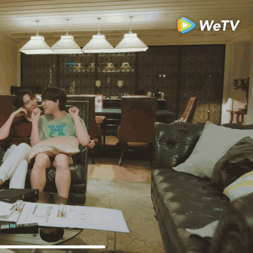 a couple sitting on a couch with the wetv logo in the background