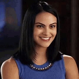 a woman in a blue tank top is smiling .