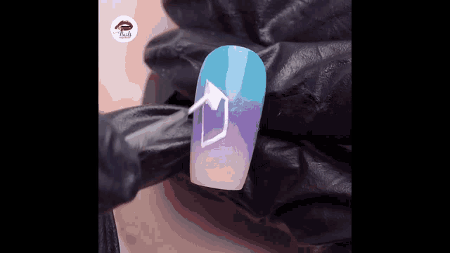 a close up of a person applying nail polish to a nail with a brush .