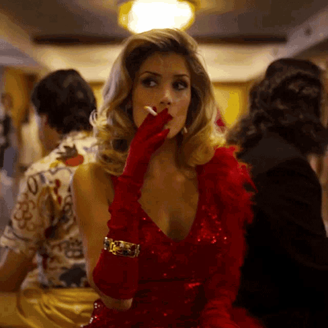 a woman wearing a red dress and red gloves is smoking a cigarette