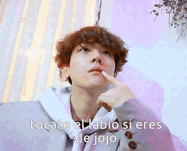 a man with his finger on his lips and the words " tocate el labio si eres de jojo " above him
