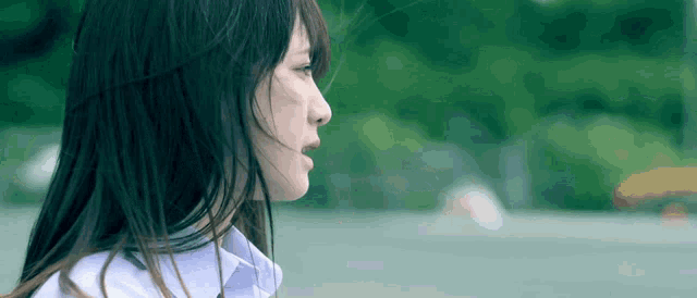 a woman with long hair is wearing a white shirt