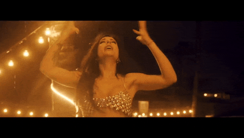 a woman is dancing with her arms in the air