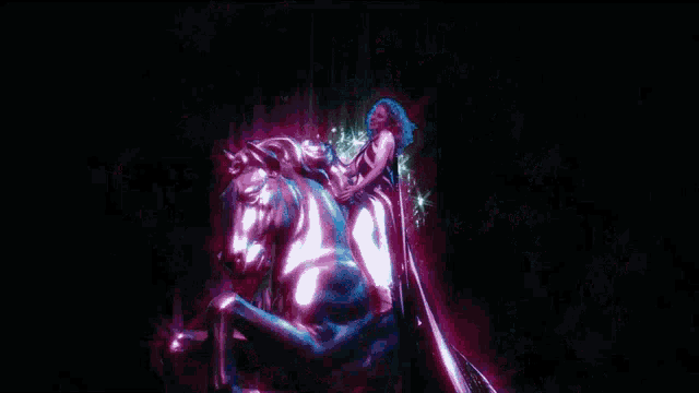 a statue of a man riding a horse is surrounded by purple stars