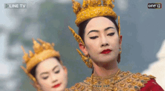two women in costume are dancing in front of a screen that says line tv