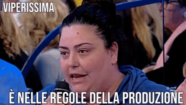 a woman talking into a microphone with the words viperissima e nelle regole della produzione below her
