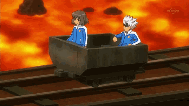 two anime characters are sitting in a wagon on a train track with a tv channel behind them