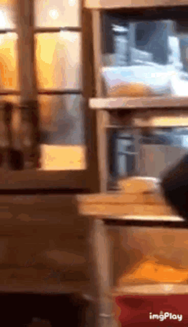 a person is standing in front of a window in a kitchen with a bunch of boxes in it .