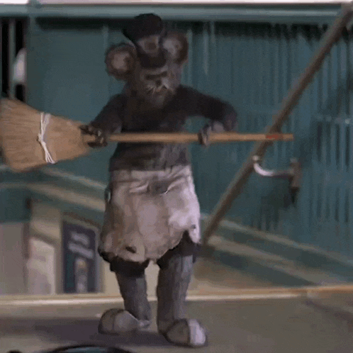 a mouse holding a broom in front of a sign that says ' a '